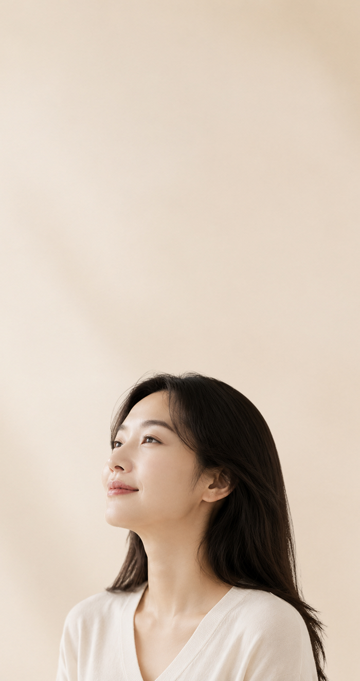 밝은 배경에서 옆을 바라보는 여성